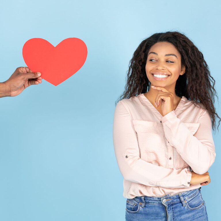 Guardar Descargar vista previa African american woman expressing happiness, man giving red heart shaped card to lady, female looking at it and smiling.